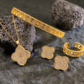 Gold jewelry set including necklace, bracelet, and earrings on a stone surface